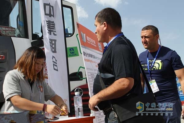 在亞歐博覽會室外嘉年華展區(qū)，聯(lián)合卡車營銷服務(wù)人員正在接待兩名俄羅斯客戶